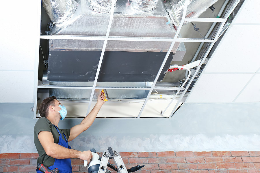 man cleaning an air vent